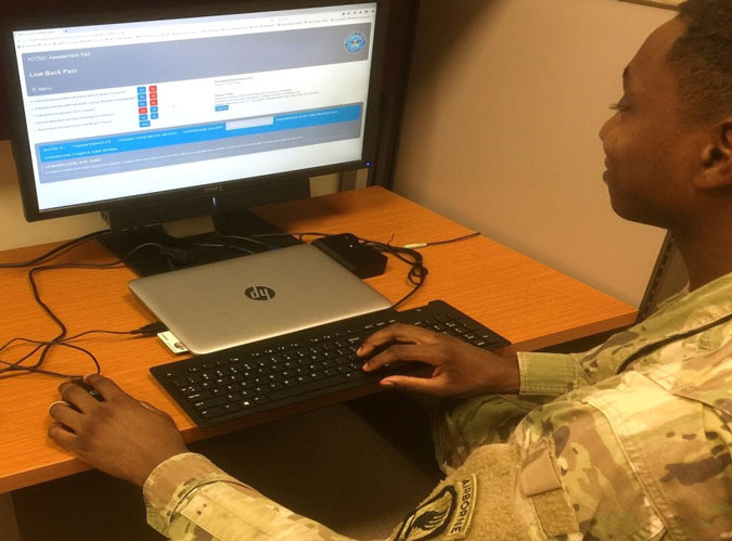 Medic utilizing the ADTMC manual at a Battalion Aid Station. 