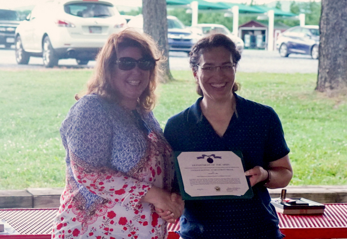 Ms. Little receiving an award from COL Adam.