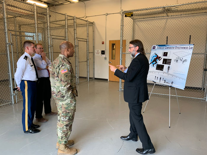 Mr. Geoff Miller (right) briefs and presents to Brigadier General Michael Talley (center) the plans for TATRC’s new Technology Comparative Effectiveness Lab, as COL Jeremy Pamplin and Dr. Robert Walker look on.