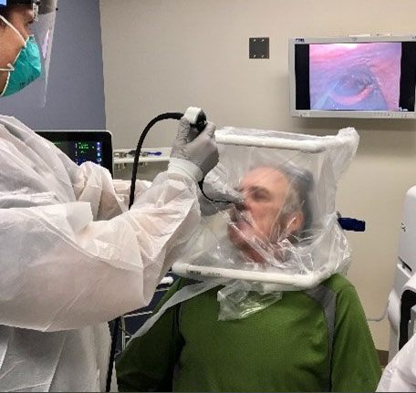 Figure 3. FEES CAMIC design variant that allowed an endoscopist and speech therapist to safely perform a swallow study. Pictured MAJ Paul Wistermayer; Photo courtesy of LTC Douglas Ruhl.