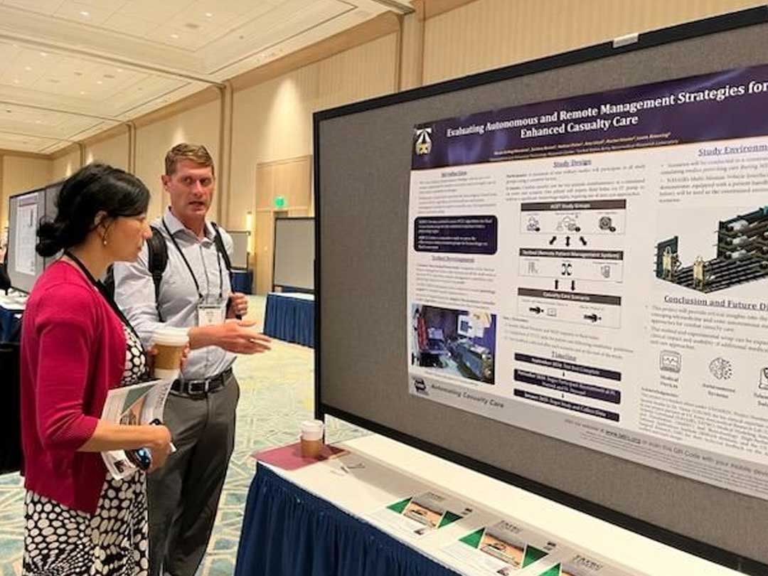 Photo of MedRAS Functional Area Lead with the poster presentation
