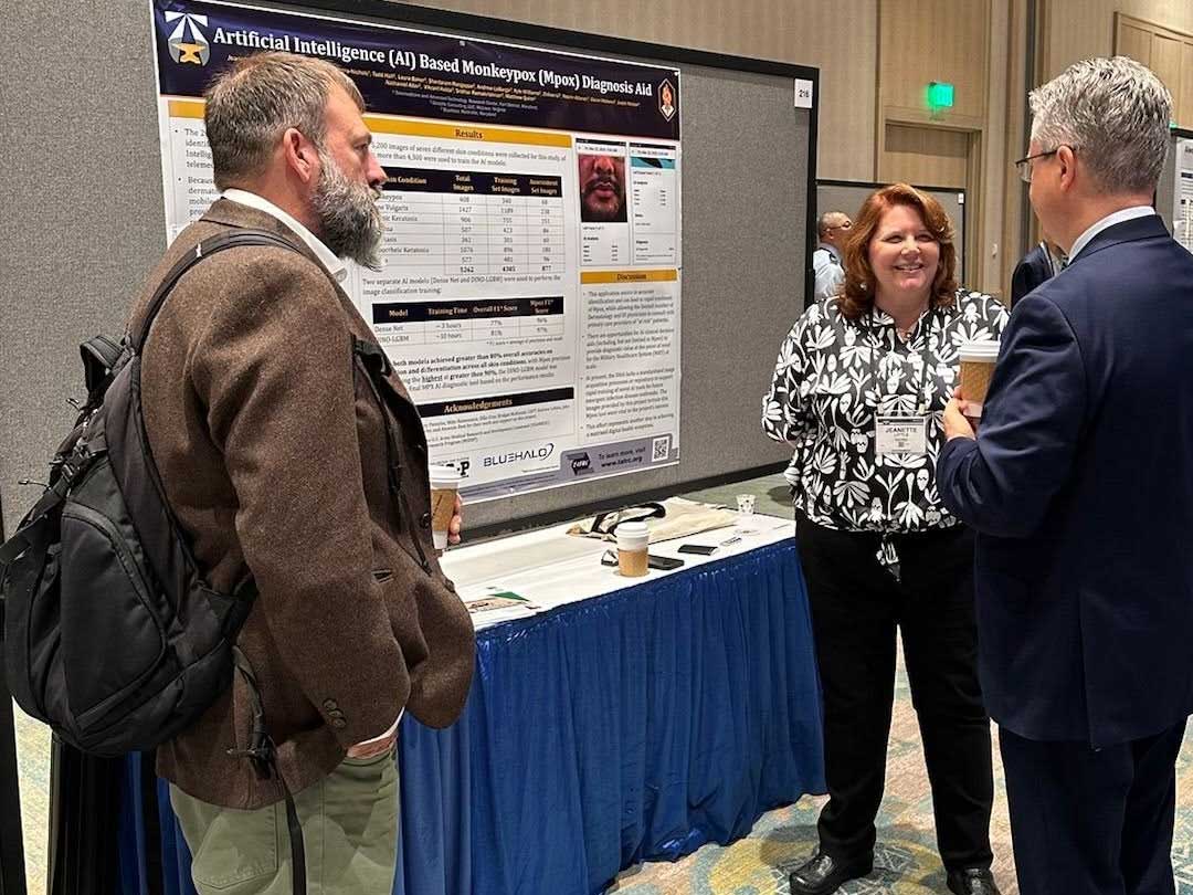 Photo of STIMS Functional Area Lead with the poster presentation